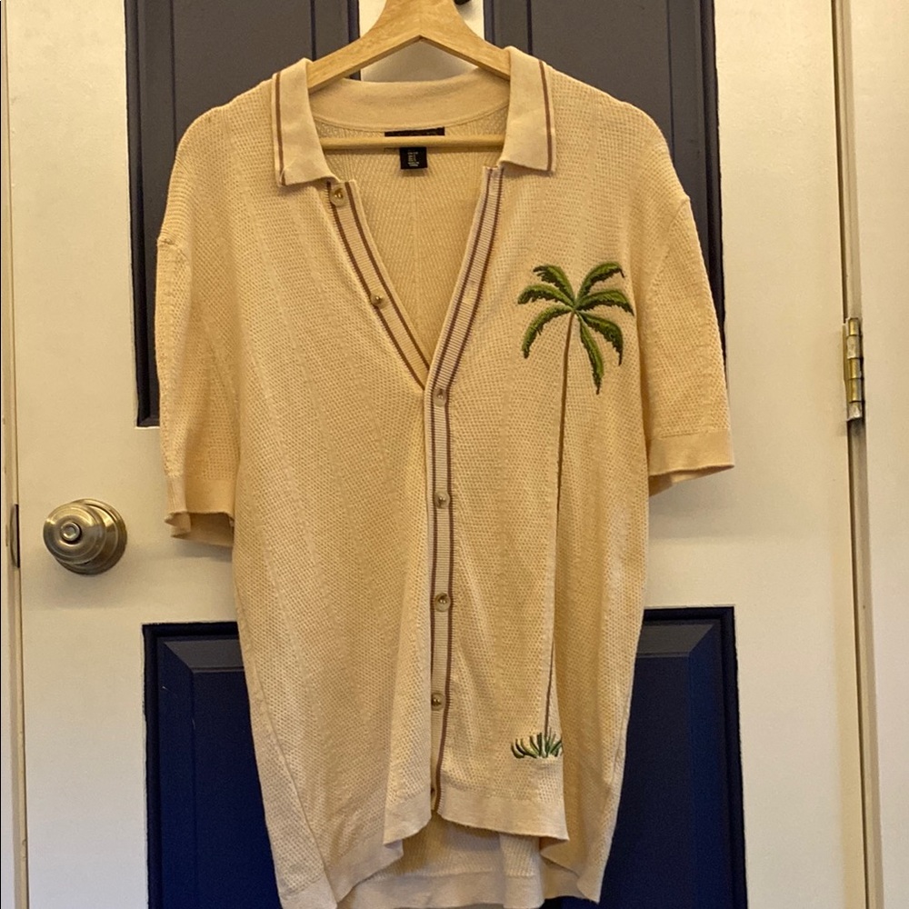 Art of Rhetoric knit polo with a palm tree on the side.